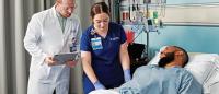 Two Columbia Nursing providers testing vitals on a patient